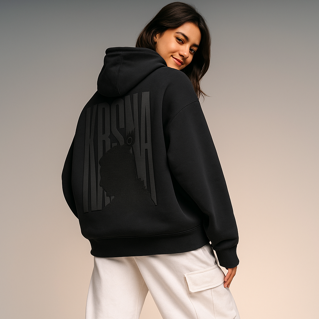 Person wearing a black hoodie with a brand logo on the back against a plain background