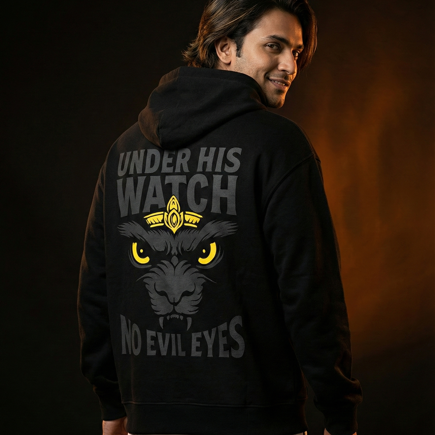 Person wearing a black hoodie with a graphic design on the back against a dark background
