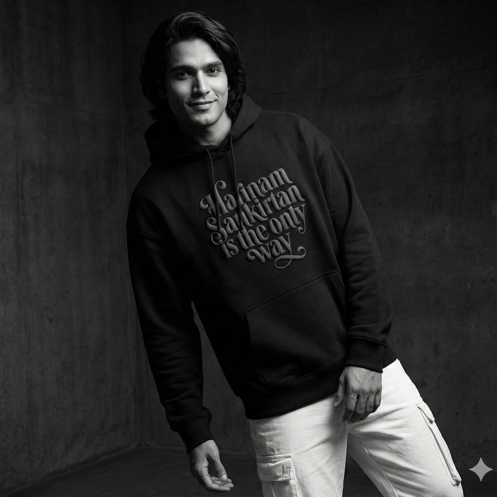 Person wearing a black hoodie with text against a dark background