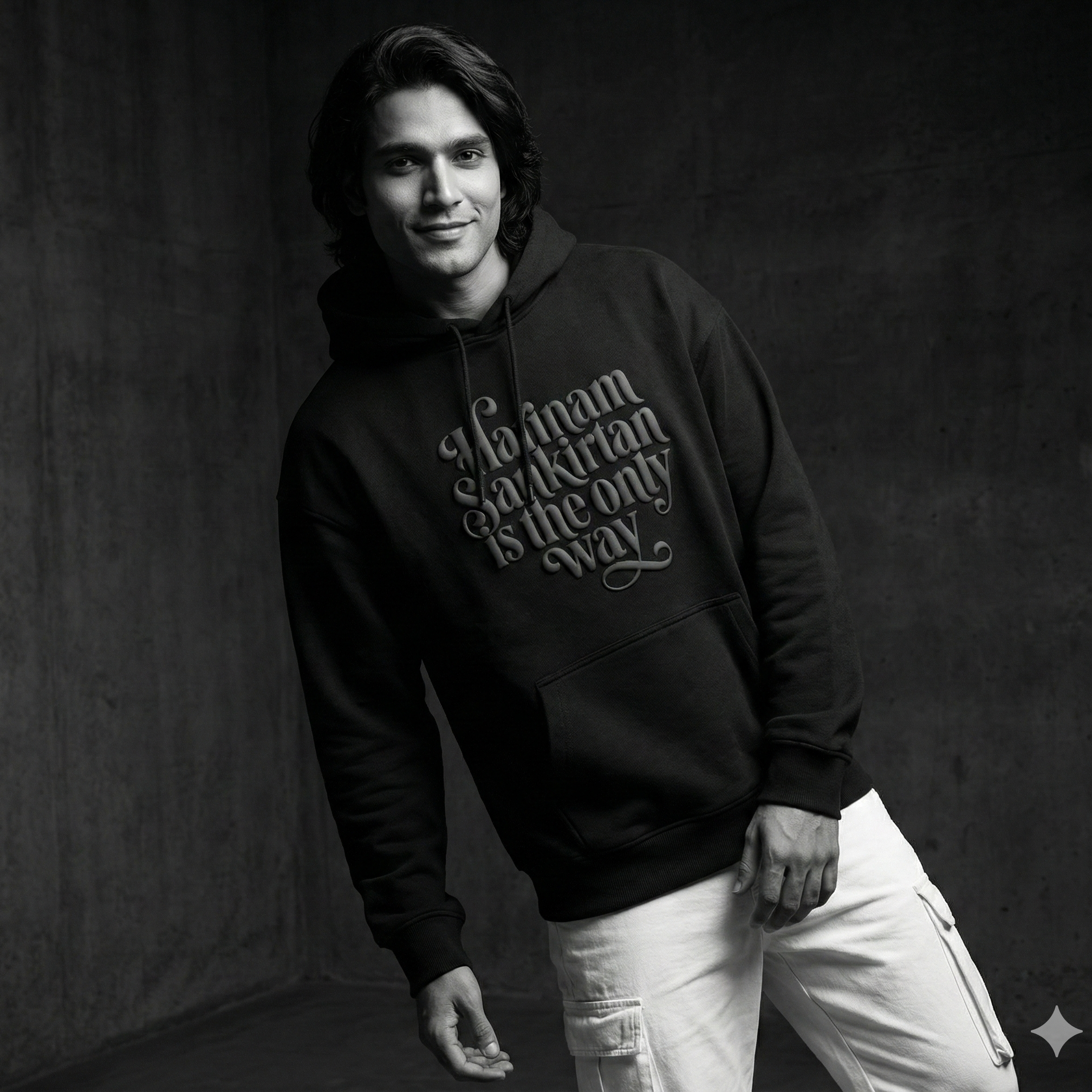 Person wearing a black hoodie with text against a dark background