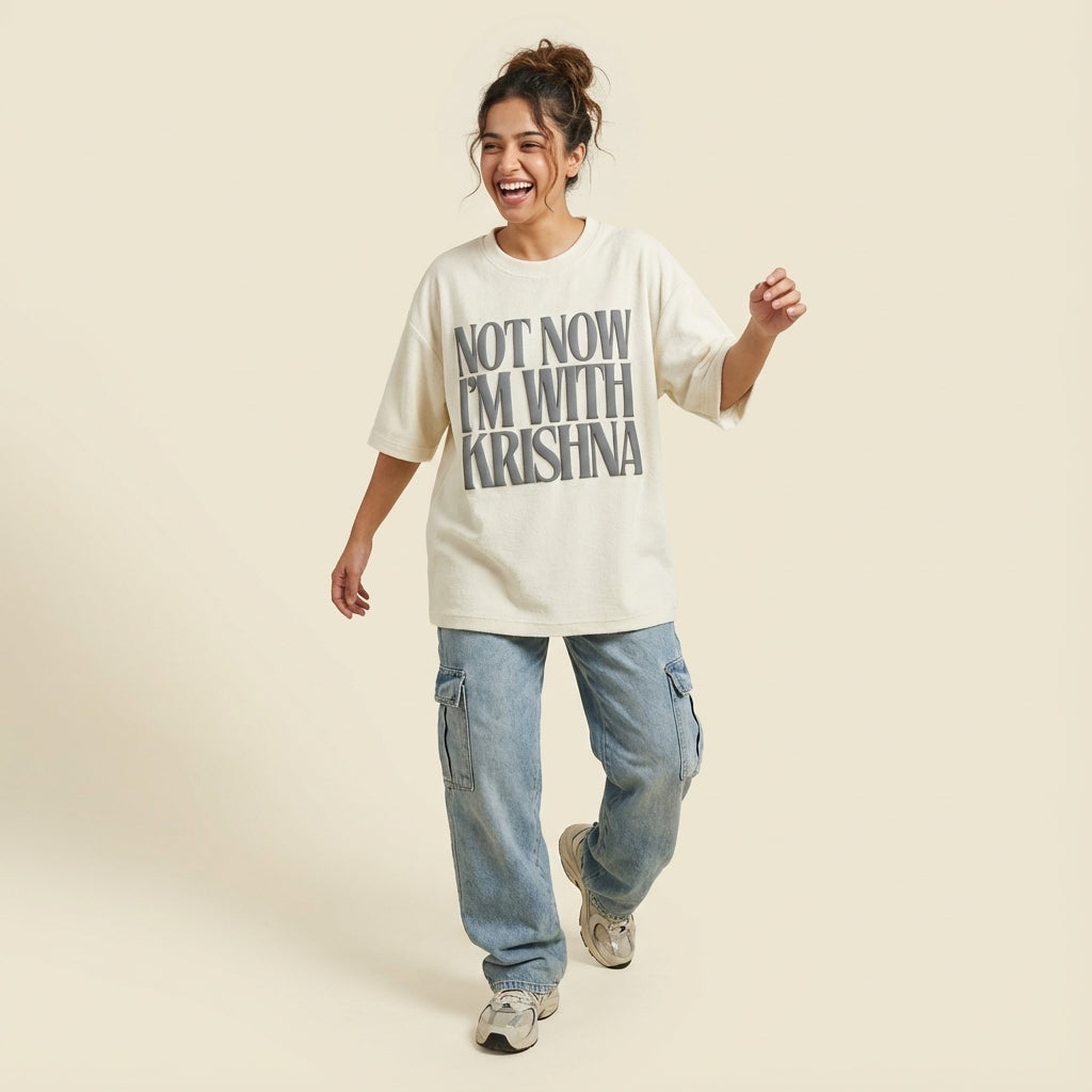 Person wearing a white t-shirt with text, standing against a plain background