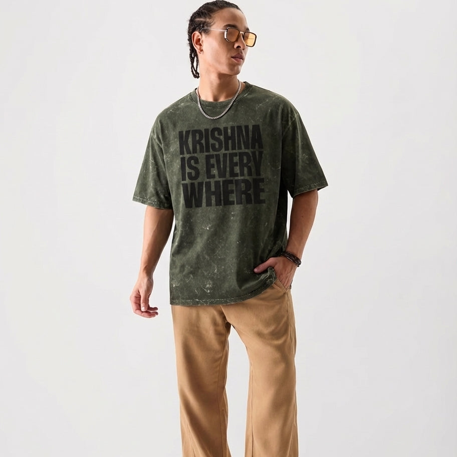 Person wearing a green t-shirt with 'Krishna is Everywhere' text on a white background