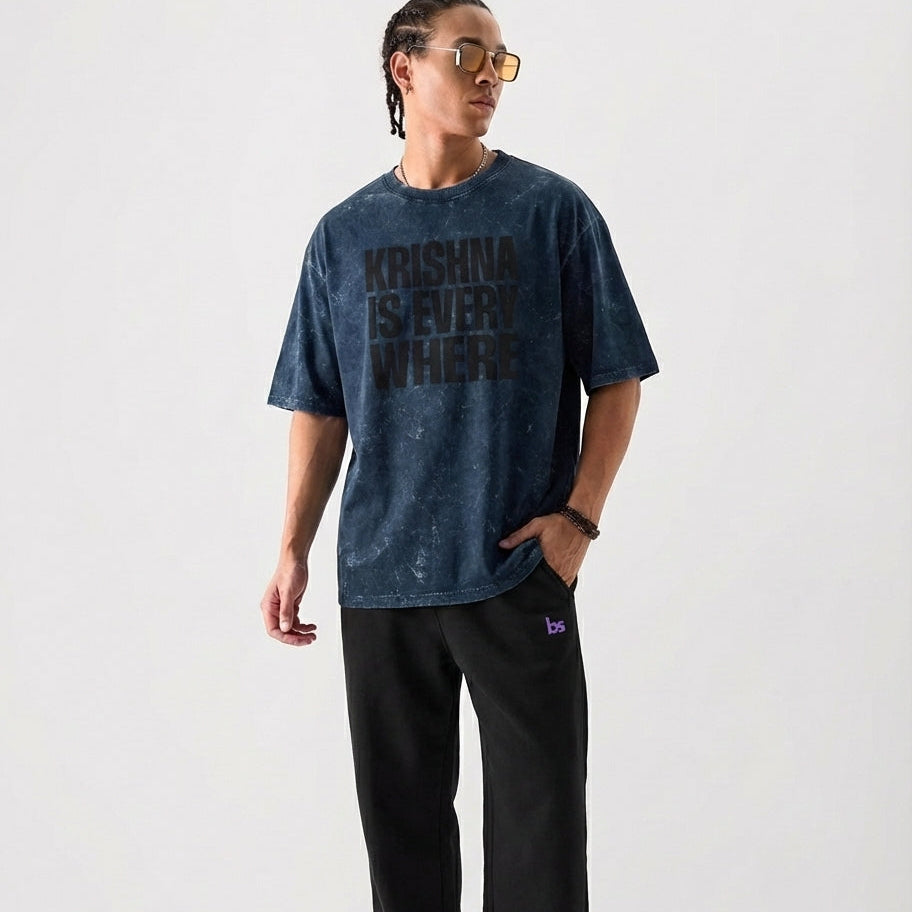 Person wearing a blue t-shirt with 'Krishna is Everywhere' text on a white background
